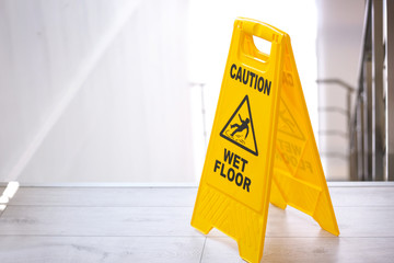 Safety sign with phrase Caution wet floor near stairs. Cleaning service