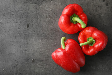 Raw ripe paprika peppers on grey background, top view