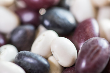 Multi-colored beans on a white background. Red and white beans in a background. Assortment of dried multi-colored beans, healthy ingredient. Bright multi-colored beans. A complete source of protein.