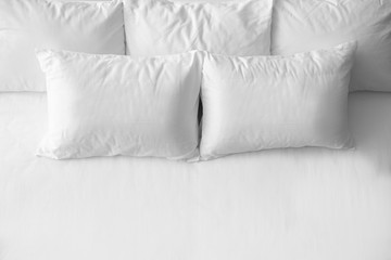 Fototapeta na wymiar Soft pillows on comfortable bed, top view