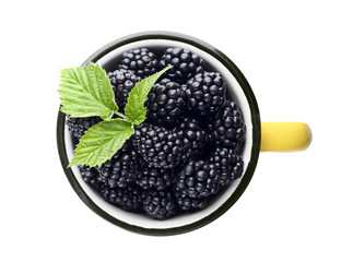 Mug with ripe blackberries on white background, top view
