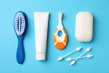 Flat lay composition with baby toothbrush and toiletries on color background