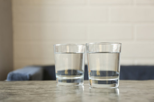 Glasses of water on grey table indoors