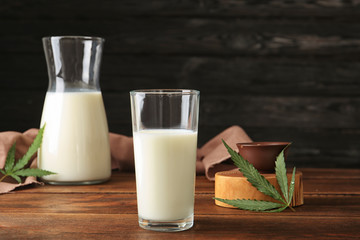 Glassware with hemp milk on wooden table