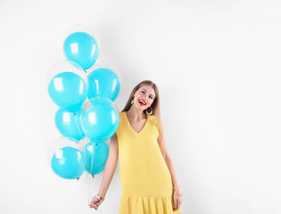 Fototapeta na wymiar Young woman with air balloons on white background