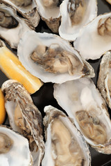Fresh oysters with cut juicy lemon, top view