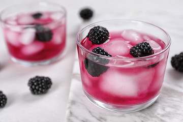 Glasses with iced blackberry lemonade on table