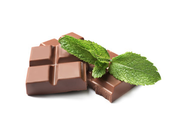 Pieces of milk chocolate with mint on white background