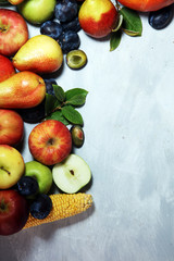 Various fresh fruits. Thanksgiving pumpkin, apples, and maize on rustic background.