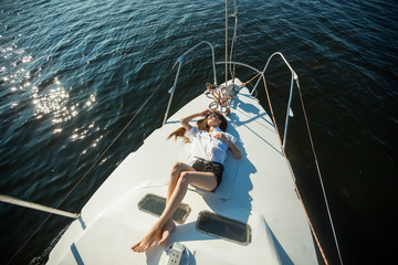 Obraz premium Girl lying on the bow of the yacht, ship