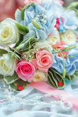 a bridal bouquet with fresh flowers. Flowers are pink, blue, white. The bouquet is decorated with birds