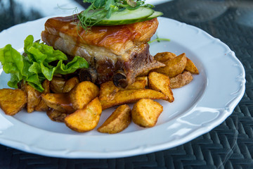 pork ribs served with fried potatoes and decorated with herbs on a plate gourmet creative food concept