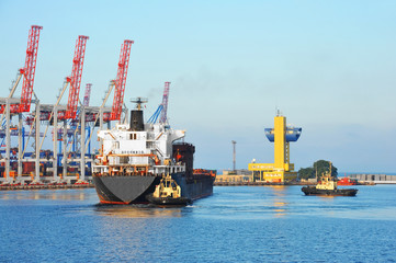 Tugboat assisting bulk cargo ship
