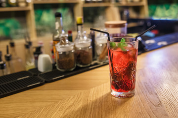 ready red alcohol cocktail on background bars of spices in an elite bar for making cocktails Cinnamon Rosehip Clove Drunk Cherry