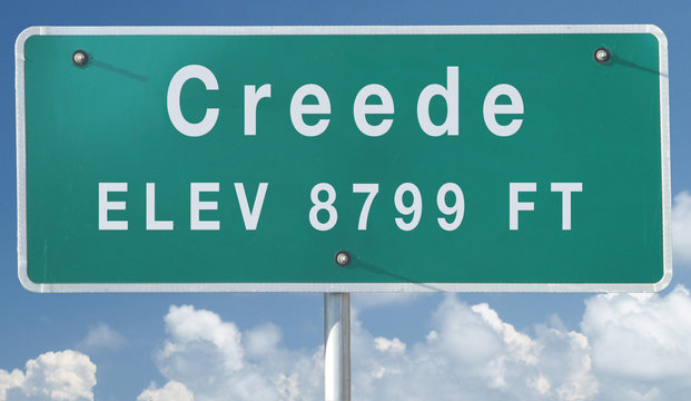 Creede, Colorado City Limit Sign with Elevation and Cloudy Sky Background
