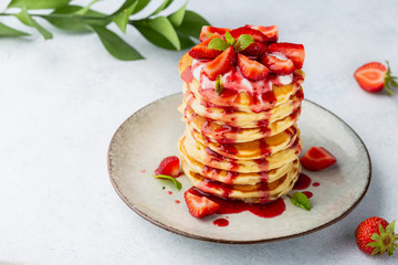 Pancakes with strawberries, topped yoghurt and strawberry syrop