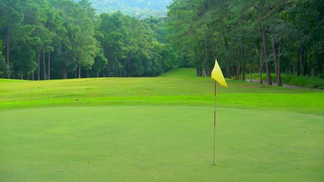 Beautiful golf course on mountain, fairway and layout beauty in forest. Flag on green golf.