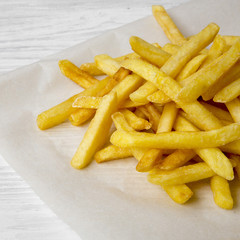French fries on a white wooden background, side view. Close-up.