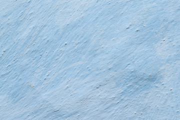 Aged adobe whitewashed wall in light-blue color, retro background, detailed texture