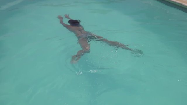 Woman swimming and diving in outdoor swimming pool