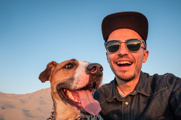 Funny best friends concept: human taking a selfie with dog. Happy young male person makes self...