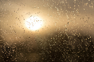 Rain outside the window during sunset. Bright texture of water droplets