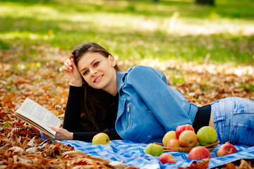 girl reading a book, a beautiful girl on a picnic in the fall with a book in her hands