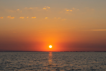 un soleil orange au dessus de la mer
