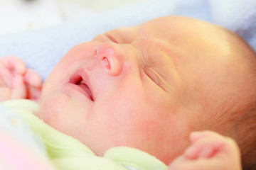 Little newborn baby sleeping calmly in blanket