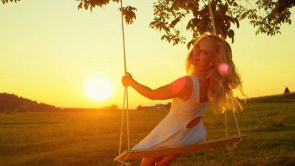 Beautiful lady enjoying summer evening in golden twilight