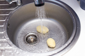 Peeled fresh potatoes in the kitchen sink