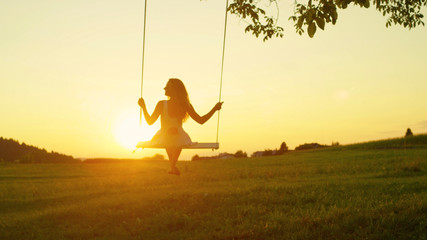 Beautiful lady enjoying summer evening in golden twilight