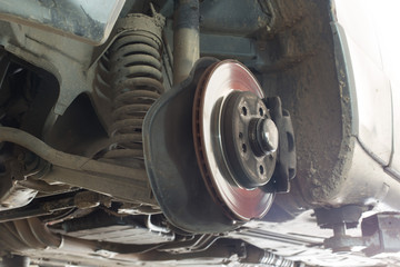 Disc brake of the vehicle for repair, in process of new tire replacement. Car brake repairing in...