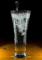 water, glass on a dark wooden background