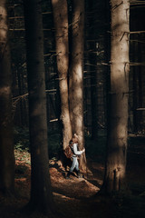 hipster traveling with backpack, walking in woods in light. wanderlust and travel concept with space for text. stylish woman hiking. atmospheric epic moment