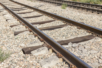Naklejka premium Railroad in motion at sunset. Railway station with motion blur effect against colorful blue sky, Industrial concept background. Railroad travel, railway tourism. Blurred railway. Transportation