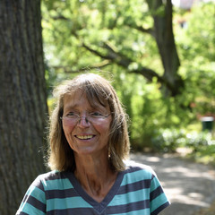 eine frau lächelt in einem park