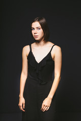 Fototapeta premium Portrait of a beautiful young Caucasian Caucasian woman 20 years old model with blue eyes natural make-up of hair on shoulder dancing hands posing on black isolated background in black lingerie