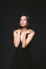 Naklejka premium Portrait of a beautiful young Caucasian Caucasian woman 20 years old model with blue eyes natural make-up of hair on shoulder dancing hands posing on black isolated background in black lingerie