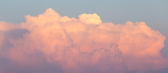 Magnificent colorful clouds in the evening sky. Bright, pink clouds in the sky at sunset. Beautiful evening skyscape. Abstract, purple pink background. Vibrant color photograph.