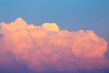 Magnificent colorful clouds in the evening sky. Bright, pink clouds in the sky at sunset. Beautiful evening skyscape. Abstract, purple pink background. Vibrant color photograph.
