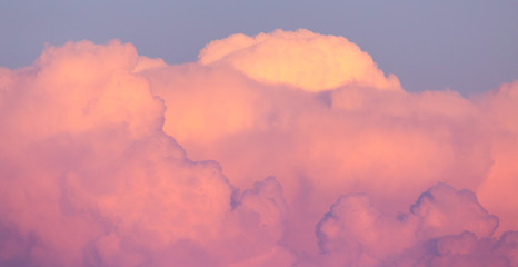 Magnificent colorful clouds in the evening sky. Bright, pink clouds in the sky at sunset. Beautiful evening skyscape. Abstract, purple pink background. Vibrant color photograph.