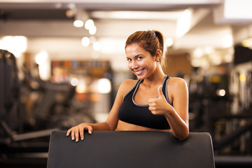 happy girl making thumbs up in a fitness club
