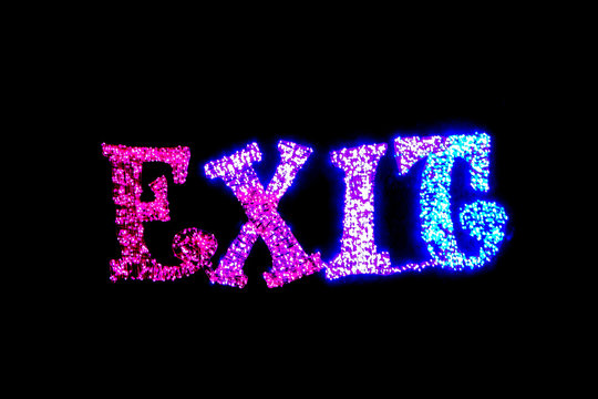 Colored bright neon exit signage lit up at night
