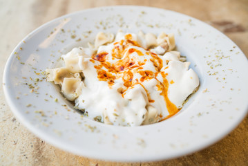 Turkish Mantı, traditional turkish food, sauce with yogurt on the turkish ravioli