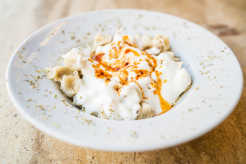 Turkish Mantı, traditional turkish food, sauce with yogurt on the turkish ravioli