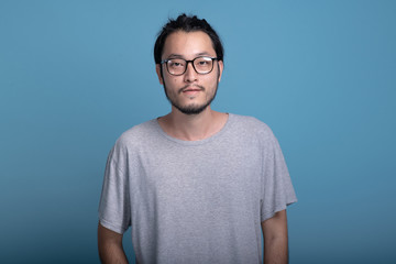 Young bearded man portrait in blue background.