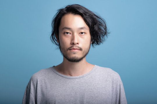 Young Bearded Man Portrait In Blue Background.