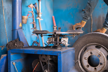 engineer balancing car wheel on balancer in workshop