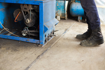 engineer balancing car wheel on balancer in workshop